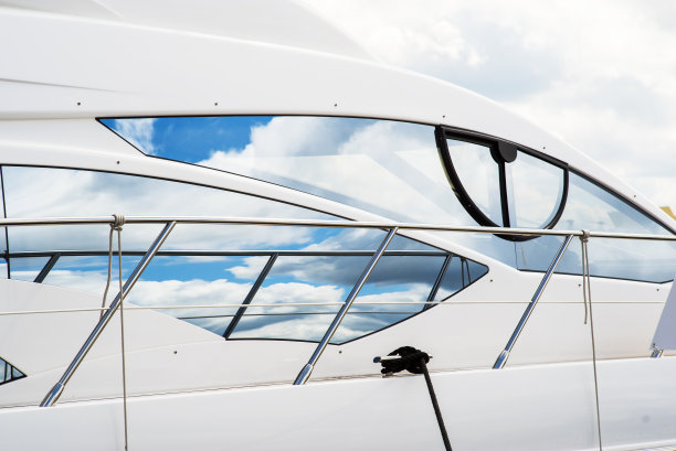 一排豪华游艇的航海背景，黑色的窗户和铬金属栏杆上的白色纤维玻璃弓图片下载