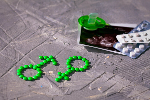 女性和男性的健康。性别象征由绿色药片或药片、假人和超声波图片制成图片下载