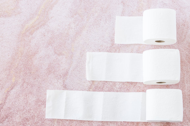 粉色背景的白色卫生纸卷图片下载