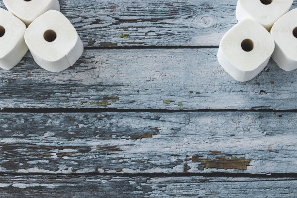 柔软的白色卫生纸卷在蓝色的木制背景上图片下载