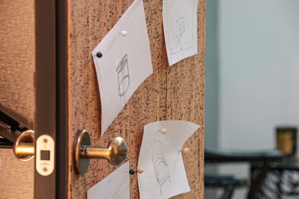 一个家具设计师的想法的草图钉在一个软木板附在门上。图片下载