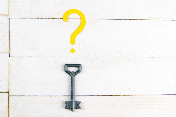 房子形状的钥匙放在带问号的木桌上。上面的观点图片下载