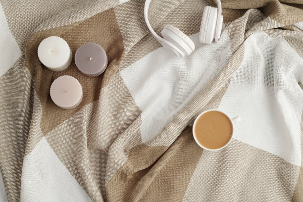 平铺三根蜡烛，白色耳机和一杯新鲜的卡布奇诺图片下载