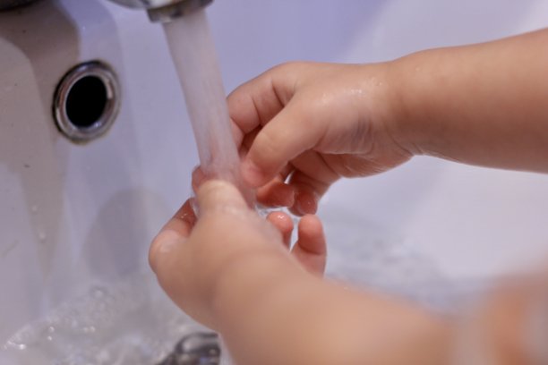 小男孩在水槽的水龙头下洗手。Сoncept卫生、疾病预防、病毒控制和应对新型冠状病毒感染的原始措施。有选择性的重点。图片下载