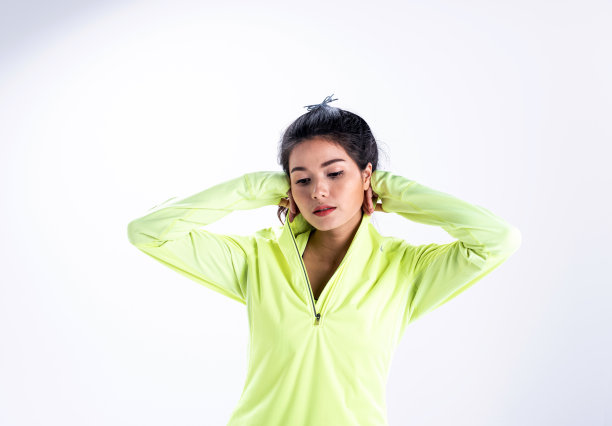 身穿绿色夹克的女士在白色背景前微笑图片下载