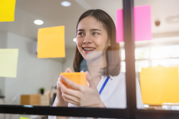 微笑年轻的亚洲女商人做笔记整理管理的工作过程。图片下载