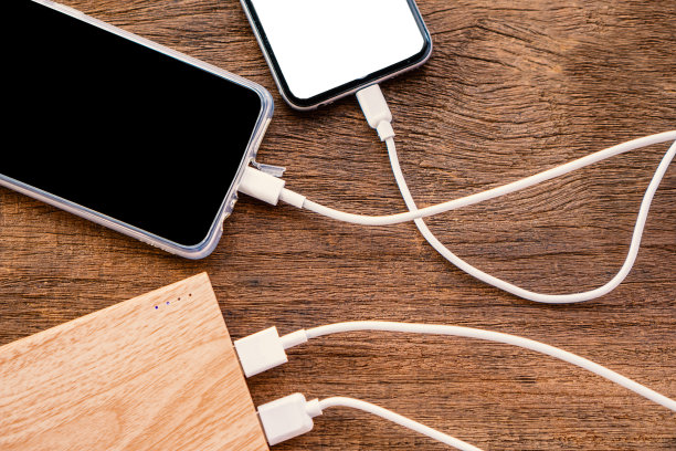 木桌上两部手机正在充电图片下载
