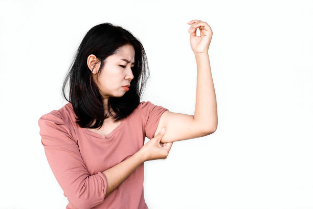 不高兴的亚洲女人手握着她肥胖的手臂，面带忧虑图片下载