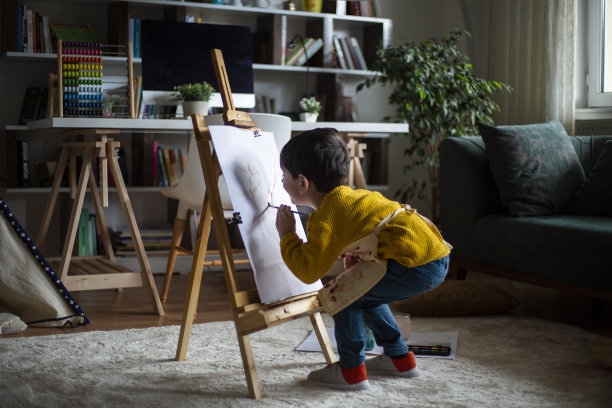 快乐的小婴儿艺术家在家里用彩色颜料画画图片下载