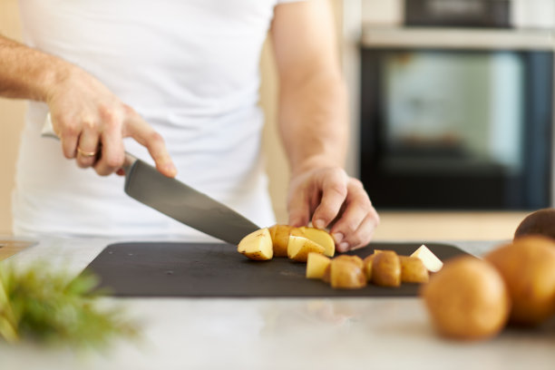 各种各样的照片，一个年轻人穿着白色t恤在一个伟大的设计厨房烹饪健康的食物图片下载