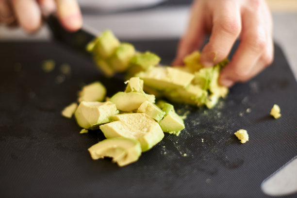 各种各样的照片，一个年轻人穿着白色t恤在一个伟大的设计厨房烹饪健康的食物图片下载