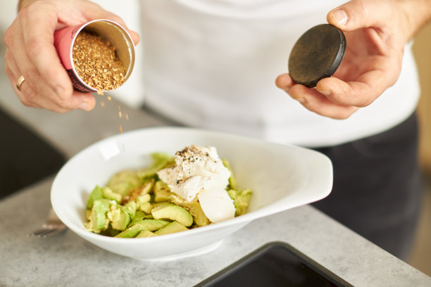 各种各样的照片，一个年轻人穿着白色t恤在一个伟大的设计厨房烹饪健康的食物图片下载