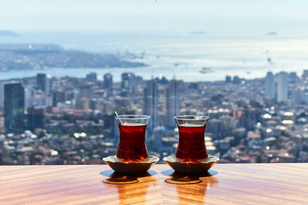 两杯传统土耳其茶(armudas)放在桌子上，以伊斯坦布尔的城市景观为背景图片下载