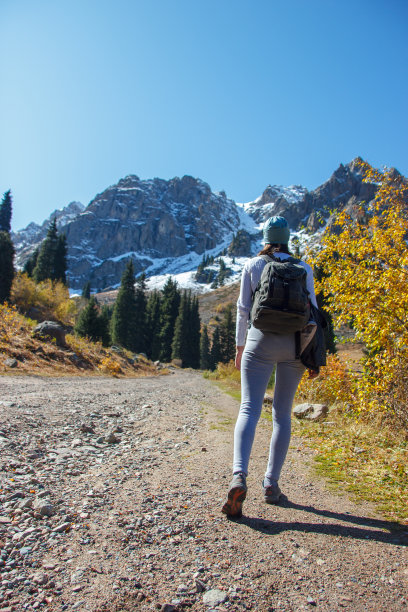 背着大背包的苗条女孩徒步登山图片下载