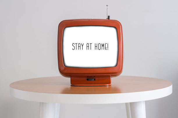 待在家里，用桌子上的老式电视屏幕发短信或信息给国家和世界的人民。有创造力。的概念。图片下载