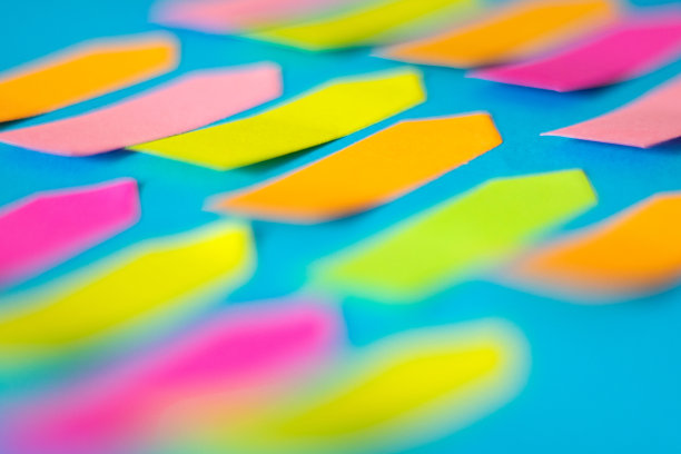 彩色的空箭头形粘纸是在蓝色的纸上图片下载