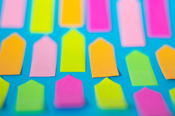 彩色的空箭头形粘纸是在蓝色的纸上图片下载