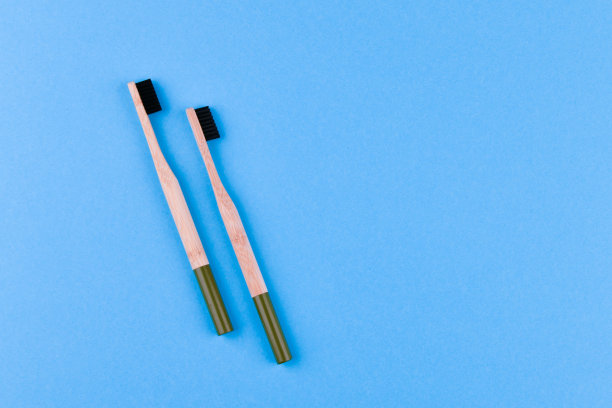 蓝色背景的木制牙刷。把木质牙刷放在蓝色背景上。eco刷图片下载