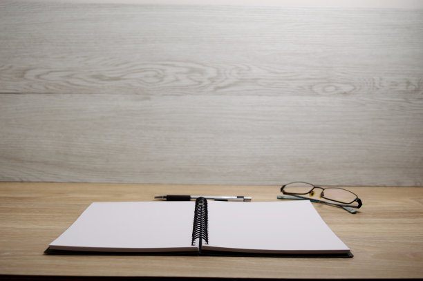 空白的笔记本页打开在木桌与木墙图片下载