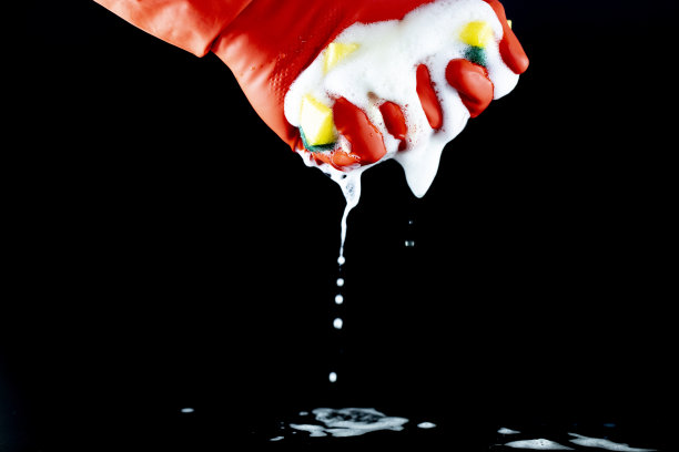 精练海绵发泡手套和黄色清洁布。在黑色背景。Clse。图片下载