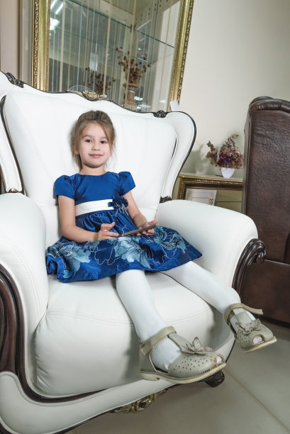 一个漂亮女孩的肖像，她坐在一个漂亮的昂贵的椅子上图片下载