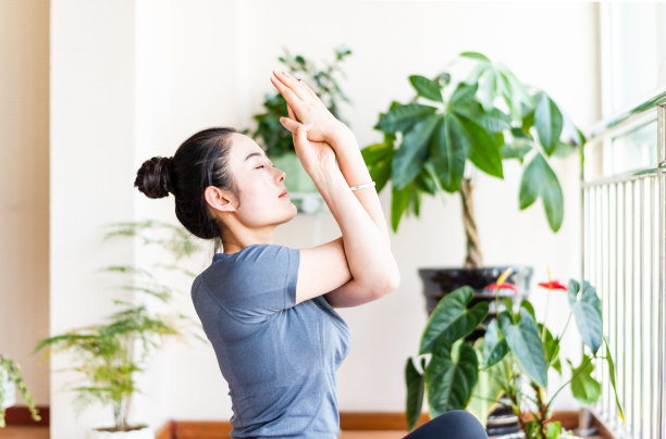 一个亚洲年轻女子在客厅里练瑜伽图片下载