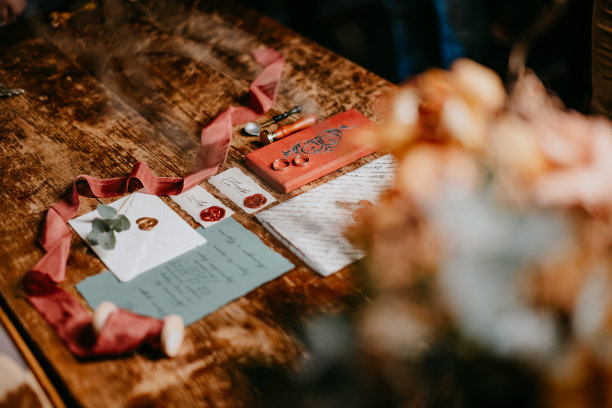 图形艺术美丽的婚礼书法卡片与花和雪纺纱筒子在木头背景。美丽的婚礼的邀请。布料，测谎和花的细节。结婚戒指。图片下载