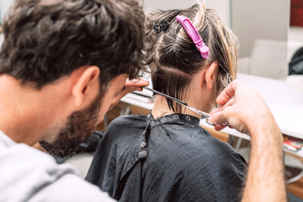 美发师在沙龙里为金发美女理发。近距离的照片图片下载