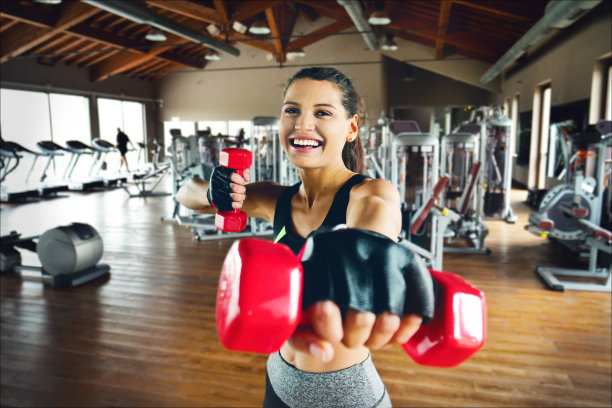 一个美丽的微笑的女人在健身房训练，既运动设备和自由的身体，以保持健康和调整图片下载
