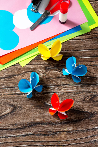 蝴蝶纸装饰或夏天的花环在木桌上。手工纸的想法。儿童创意项目，工艺品，儿童工艺品。空间的文本。图片下载