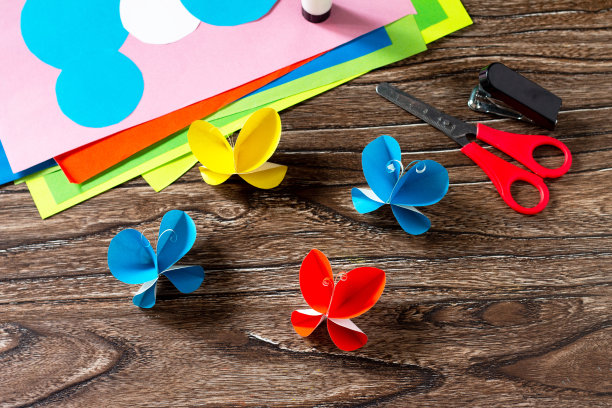 蝴蝶纸装饰或夏天的花环在木桌上。手工纸的想法。儿童创意项目，工艺品，儿童工艺品。图片下载