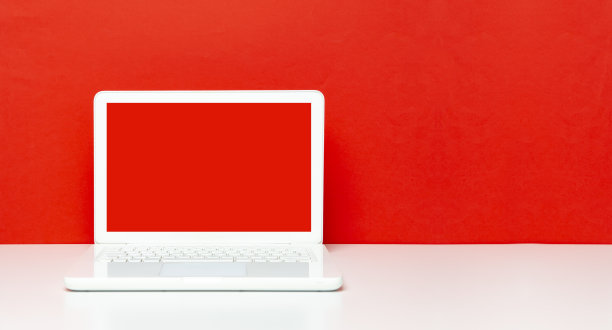 办公桌上的红屏笔记本电脑图片下载