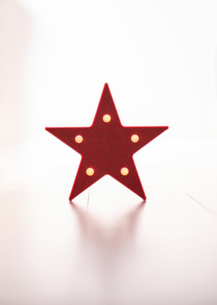 极简主义的概念，一盏星形的灯矗立在拼花地板上，映衬着明亮的背景图片下载