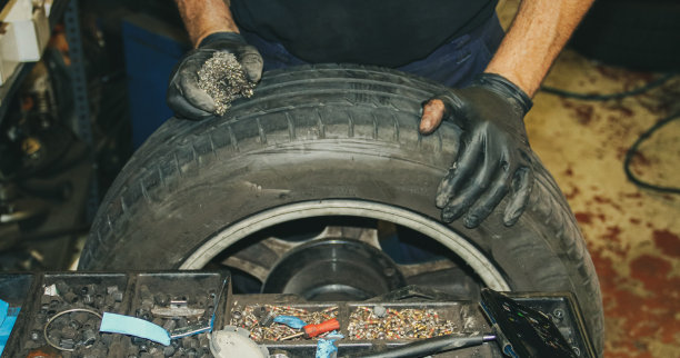 机修工的双手正在修理轮胎上的漏气。图片下载