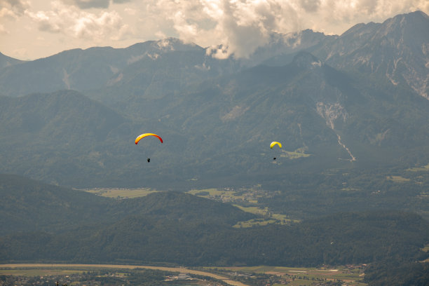 全景奥地利阿尔卑斯山在奥西切尔湖看到与卡拉瓦肯山脉的山与滑翔伞图片下载