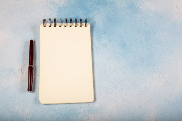 小螺旋笔记本与钢笔，孤立在白色。图片下载