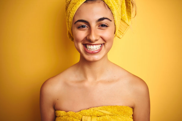 年轻漂亮的女人穿着浴巾自信微笑图片下载