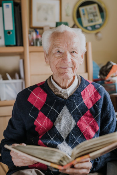 一个老人正在看旧相册里的家庭照片图片下载