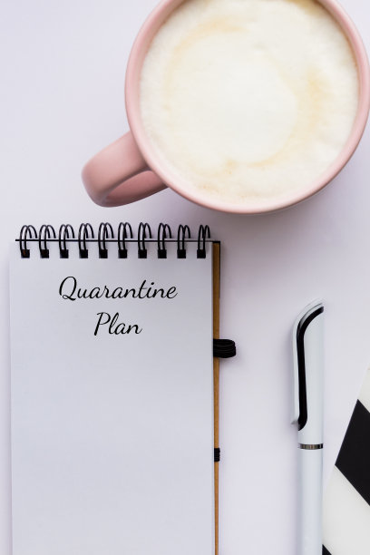 因covid - 19大流行而留在家中的隔离计划。家庭办公室的布局。笔记本和一杯卡布奇诺图片下载