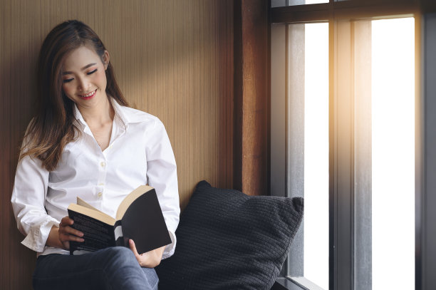 年轻女子快乐地读书。图片下载