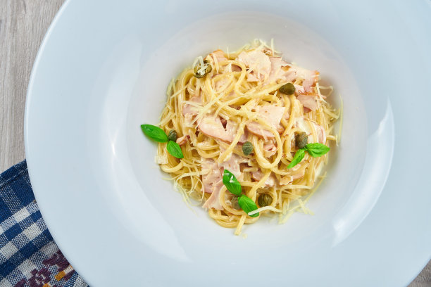 美味的自制干酪意面配培根，奶油酱和罗勒在一个白色盘子里。特写，俯视图。意大利面，食谱照片图片下载