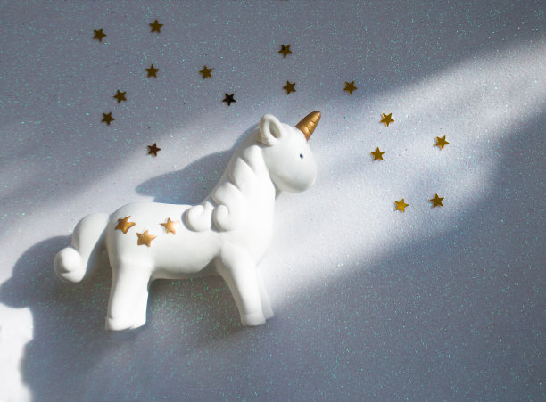 闪亮的白色背景上有星星的小独角兽。魔术的概念，童年的梦想，现代的趋势为广告的普遍图片下载