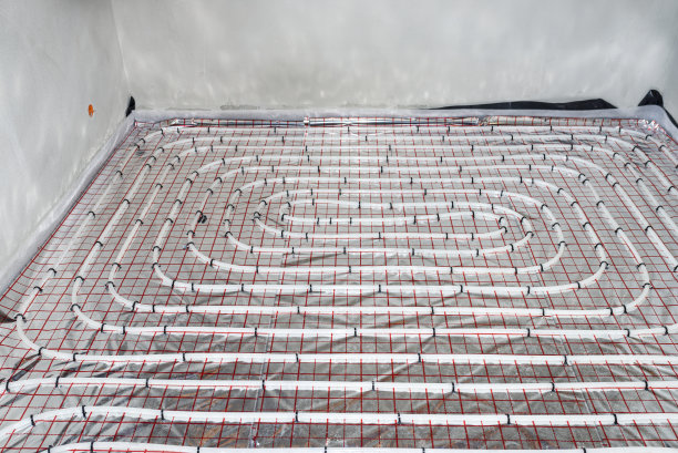 地板下采暖系统的白色管道，分布在单个家庭住宅的隔热箔上。图片下载