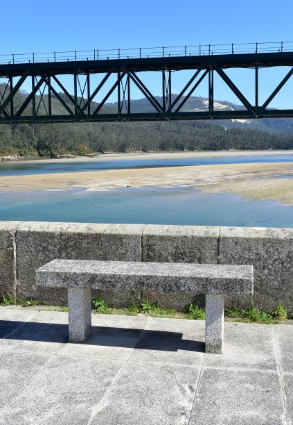 海滩与森林，步行与石凳和火车桥在Sor海岸河。西班牙加利西亚阿科鲁阿省O Barqueiro。图片下载