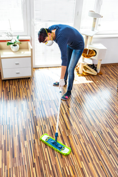 成年妇女在隔离期间打扫房间-库存照片图片下载