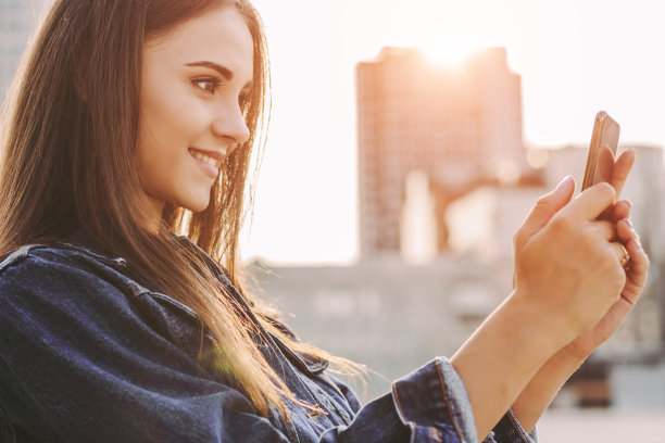 欢快的时髦女孩在城市街道上拍照图片下载