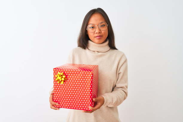 年轻的中国女子戴着眼镜，拿着生日礼物在孤立的白色背景下，聪明的脸上充满自信的表情，思考严肃图片下载