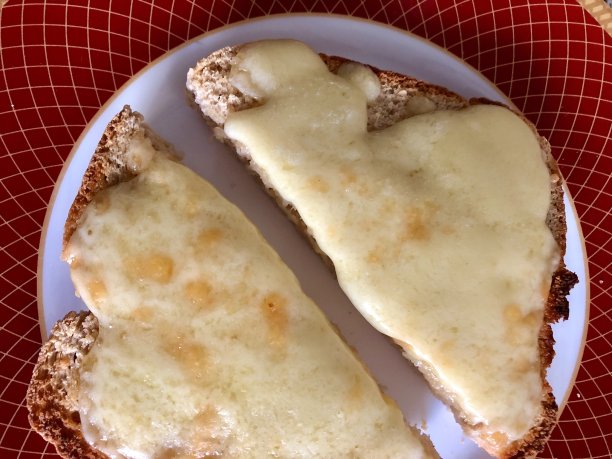 金色的，热的，融化的切达奶酪片在全麦面包，奶酪吐司上的盘子，高视阔视图片下载