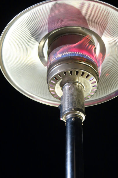 天井加热器也被称为蘑菇/伞加热器，室外花园天井加热器由燃气火焰供电，而不是电力，照片在晚上在一个普通的黑色背景图片下载