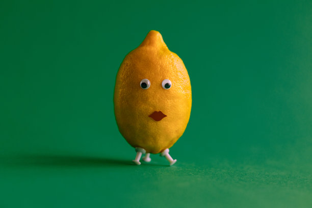 有趣的柠檬与眼睛和嘴在绿色的背景图片下载